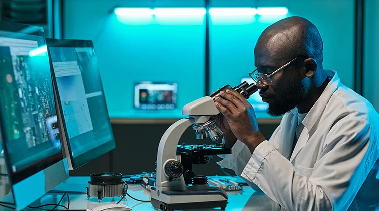 biology student looking in microscope