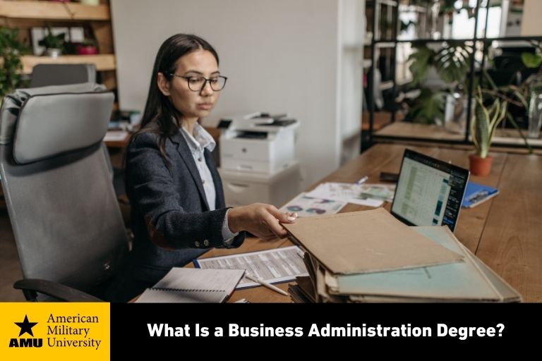 what-is-business-administration-degree business administration professional sorting through documents at desk