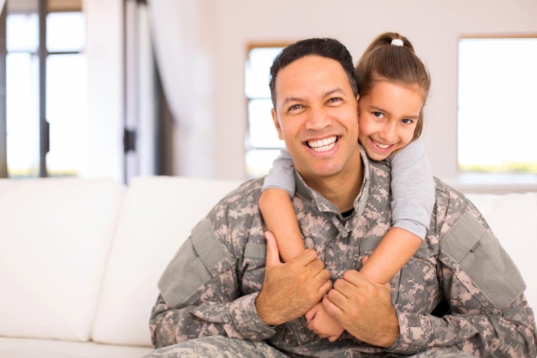 father in uniform with daughter on back